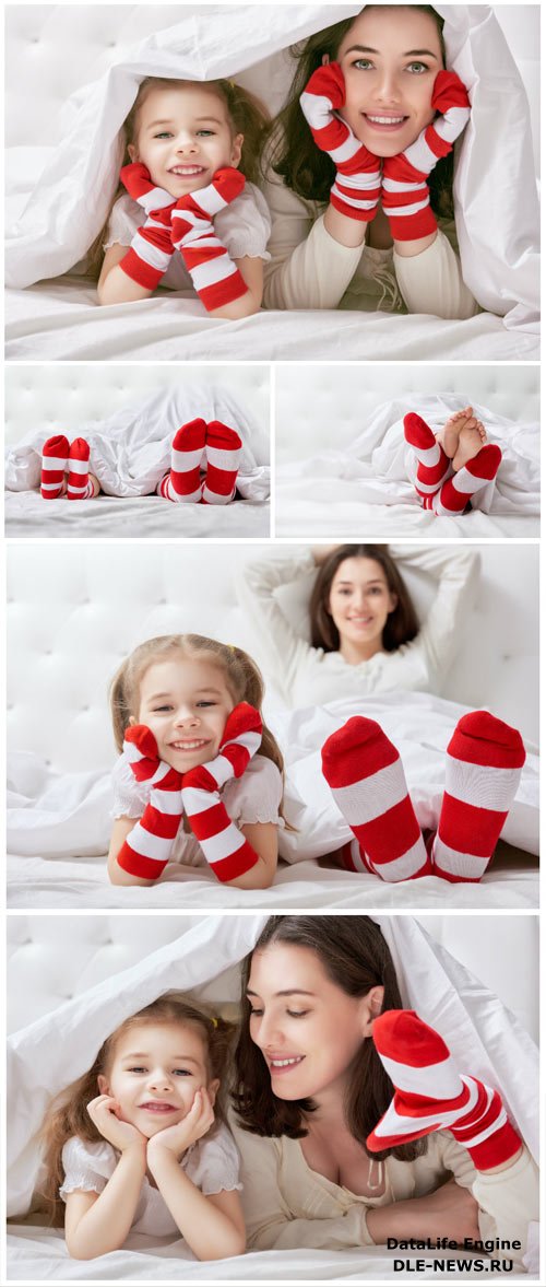 Cheerful little daughter and mom on bed stock photo